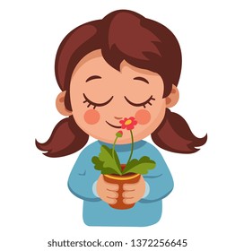 cute girl sniffs a flower in a pot