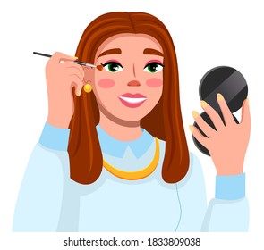 Cute girl using eye shadows, holding brush and looking in pocket mirror in hand. Beauty blogger. Brown-haired pretty woman making light makeup for herself. Lady wearing earrings, necklace accessories