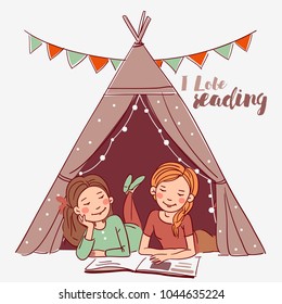Cute girls in a tepee tent reading book