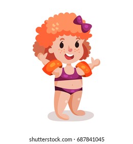 Cute happy redhead girl in purple swimsuit with inflatable armbands, kid ready to swim colorful character