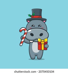 Cute hippo holding christmas candy and gift. Cute christmas cartoon illustration.