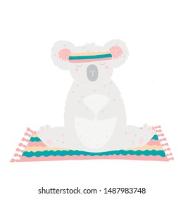 Cute koala sitting on a mat and practicing yoga in a sports armband.