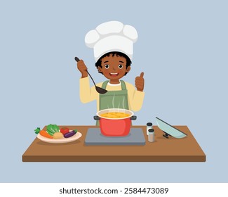 Cute little African boy chef cooking delicious vegetable soup showing thumb up