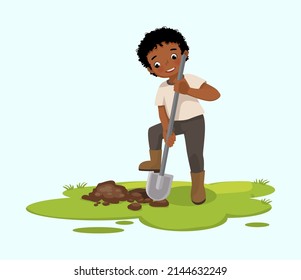 Cute little African boy digging hole on the ground with shovel in the garden