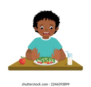 lindo niño africano picky come negándose a comer verduras