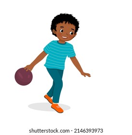 cute little African boy playing bowling in the sport club ready to throw the ball