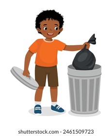 Cute little African boy taking out the trash in garbage bag into recycling bin