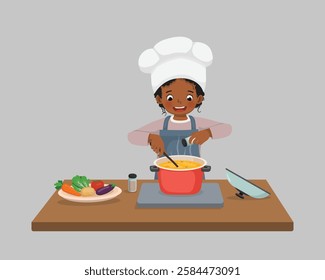 Cute little African girl chef cooking delicious vegetable soup with pan adding spices in the kitchen