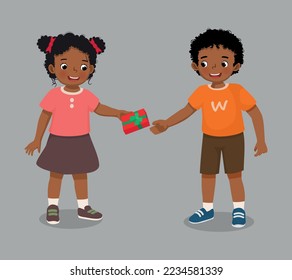 cute little African girl giving gift to a boy for his birthday or Christmas present 