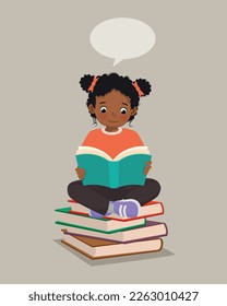 Cute little African girl reading a book sitting on the stack of books