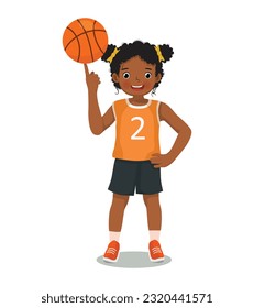 Cute little African girl with sportswear spinning basketball on her finger posing with hand on his waist