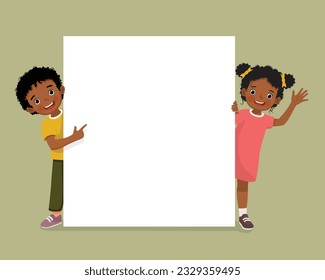 Cute little African kids boy and girl standing behind empty banner peeking and pointing finger over board