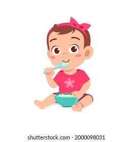 cute little baby girl eat porridge in bowl with spoon