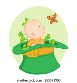 Cute little baby sitting in the big green Irish hat and looking at the butterfly