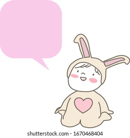 Cute little baby wearing animal costume with blank speech balloon. Happy baby in rabbit suit sitting with blank speech bubble. Little kid wearing pink bunny costume smiling with word balloon.