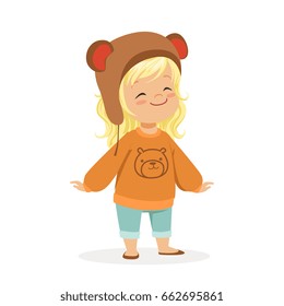 Cute little blonde girl dressed in a brown bear hat and a sweater with teddy bear colorful cartoon character