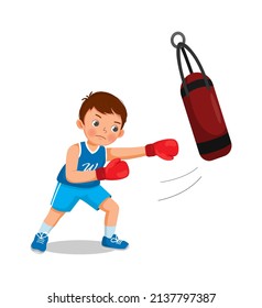 Cute little boy boxer wearing boxing gloves hitting the punching bag training and exercising in the gym