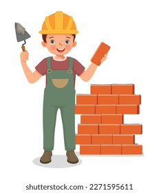 Cute little boy builder holding cement bricklayer tool working at the construction site