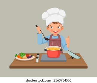 cute little boy chef cooking delicious vegetable soup showing thumb up