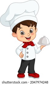 Cute little boy chef holding a silver tray