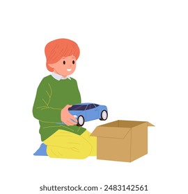 Cute little boy child cartoon character packing toy car into cardboard box before relocation