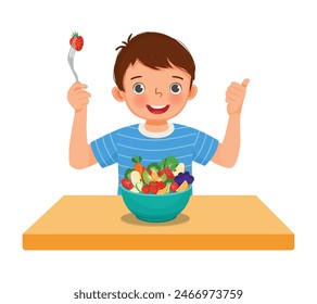 Cute little boy eating vegetables fruits salad showing thumb up