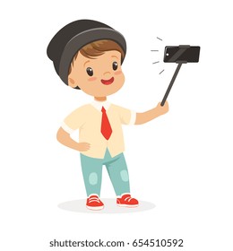 Cute little boy in fashionable clothes taking selfie with a selfie stick, colorful cartoon character vector Illustration