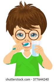 Cute little boy with glasses brushing teeth and holding glass of water, isolated on white 