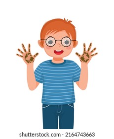 cute little boy with glasses showing his dirty hands with mud and soil dirt