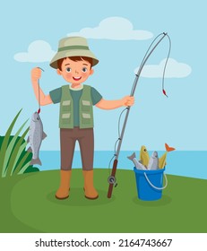 cute little boy holding big fish hook on the fishing rod standing near bucket full of fishes