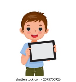 cute little boy holding digital tablet with finger pointing to empty screen or copy space for texts, messages and advertising content. Kids and electronic gadget devices concept for children.