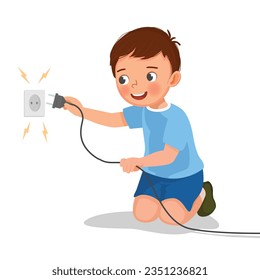 Cute little boy play with electricity put a plug into socket