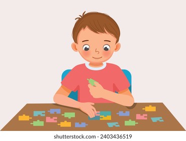 Cute little boy playing colorful puzzle at the table