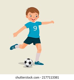 cute little boy playing soccer kicking the football to make a goal