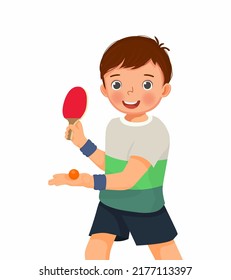 Cute little boy playing table tennis in serving position ready to strike the ping pong ball with paddle