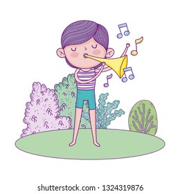 cute little boy playing trumpet in the landscape