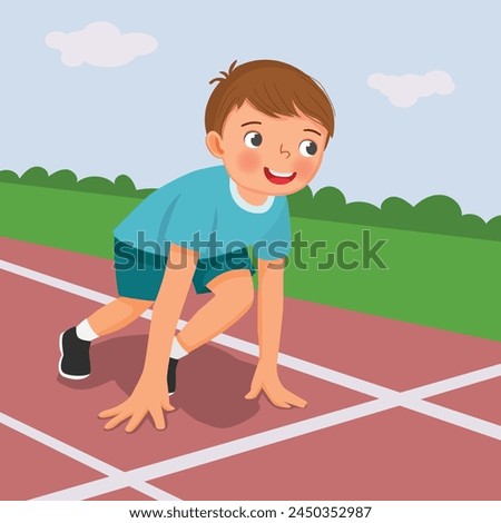 Cute little boy prepare to run on starting position at race track