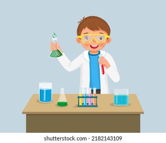 Cute Little Boy Scientist With Safety Goggles Holding Chemical Liquid In Flasks Doing Science Project  Chemistry Experiment In The Laboratory