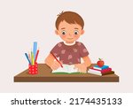 Cute little boy sitting on the desk studying writing on notebook doing her homework at home