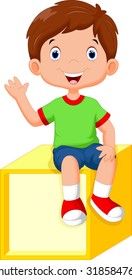 Cute little boy sitting on a cube