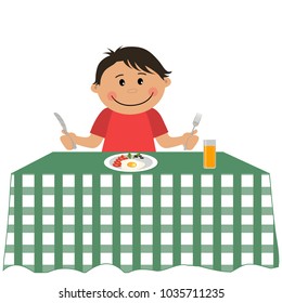 Cute little boy is sitting at a table and holding a fork and knife. On the table is a plate of food and a glass of orange juice. Vector illustration