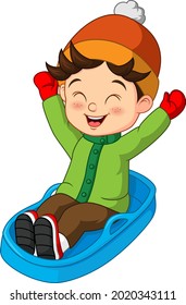 Cute little boy sledding down a hill