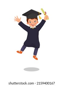 cute little boy student in graduation gown holding certificate diploma jumping in happy graduation day