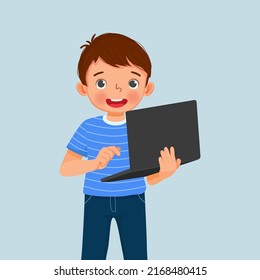 cute little boy student holding and using laptop for studying browsing and doing homework