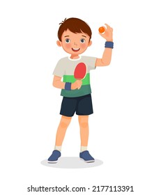 Cute little boy table tennis player holding ping pong ball with paddle ready to play