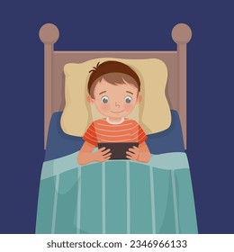 Cute little boy using smartphone lying on the bed at night