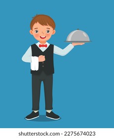 Cute little boy waiter holding silver tray serving food