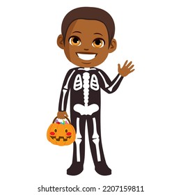 Cute little boy wearing skeleton costume   holding Trick treat pumpkin basket for Halloween party