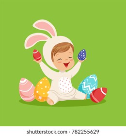 Cute little boy in a white bunny costume playing with colorful painted eggs, kid having fun on Easter egg hunt vector Illustration