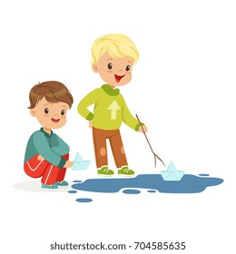 Cute little boys playing with paper boats in a water puddle cartoon vector Illustration